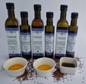 Six bottles of flaxseed oil, 250ml and 500ml, showing the difference between regular clear gold flaxseed oil and darker opaque organic high lignan flaxseed oil.