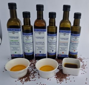 Six bottles of flaxseed oil, 250ml and 500ml, showing the difference between regular clear gold flaxseed oil and darker opaque organic high lignan flaxseed oil.